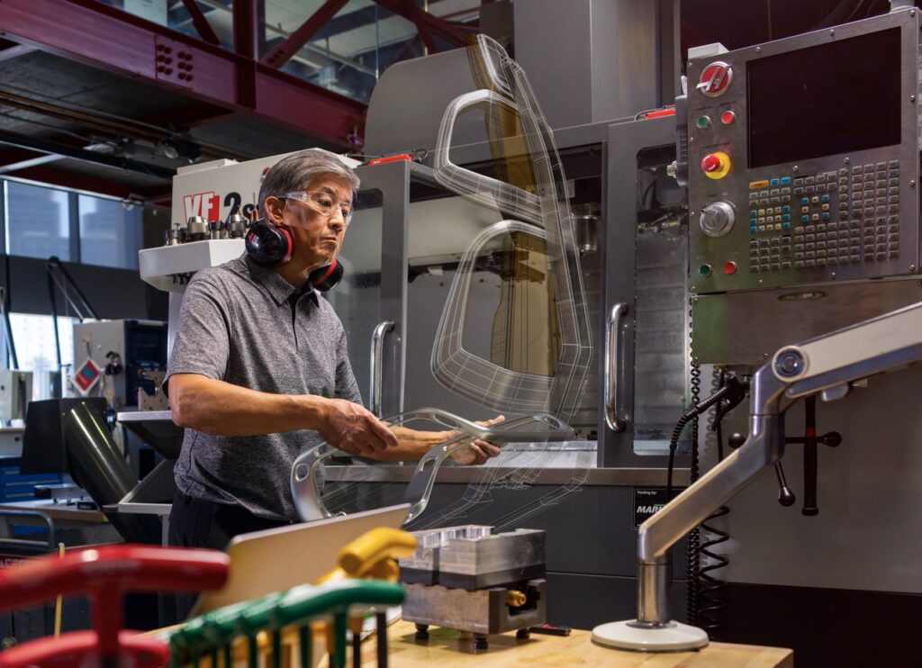 Kỹ sư làm việc tại máy CNC trong quá trình gia công chi tiết.